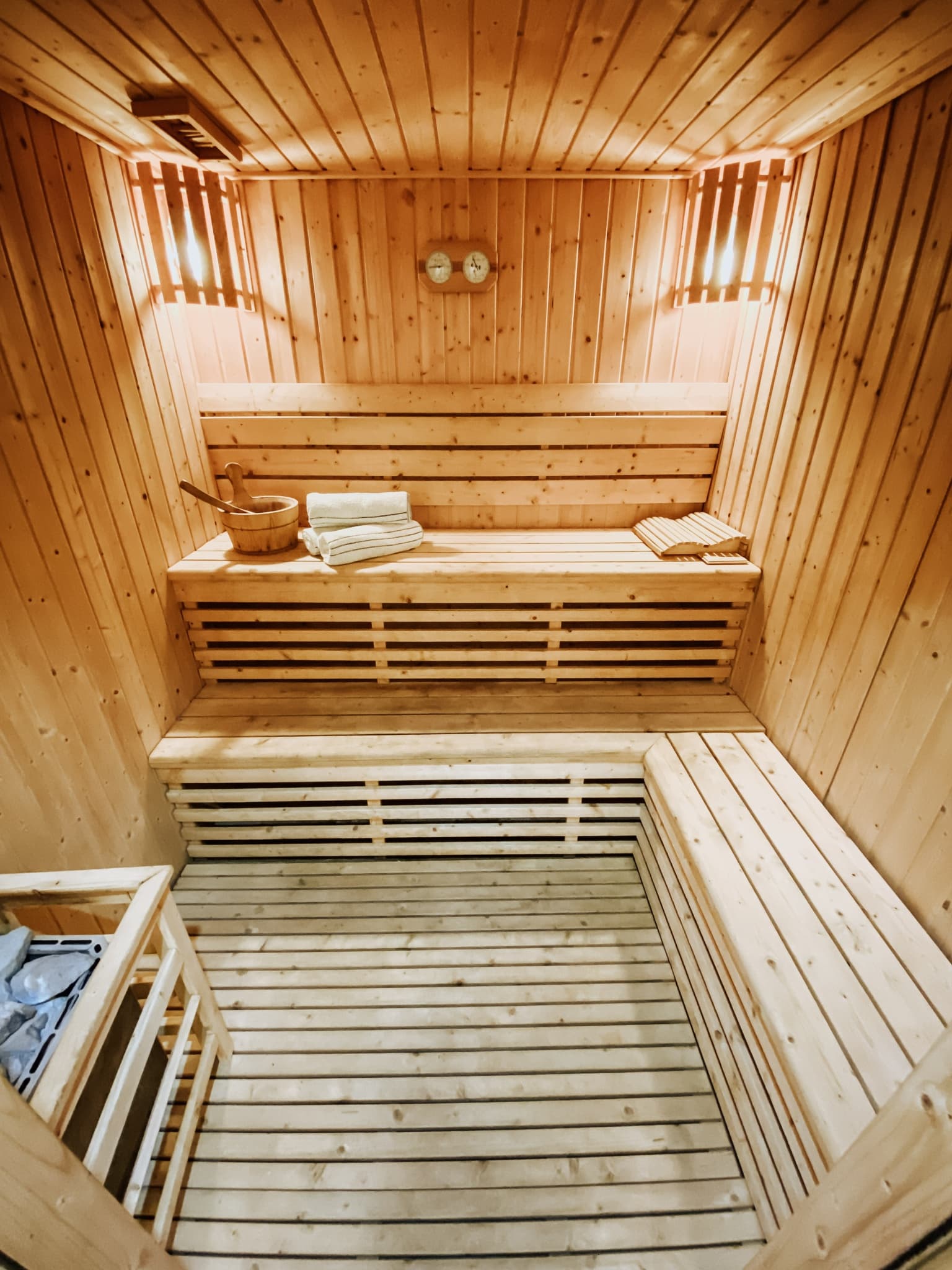 Traditional pine sauna interior with bench seating and warm lighting